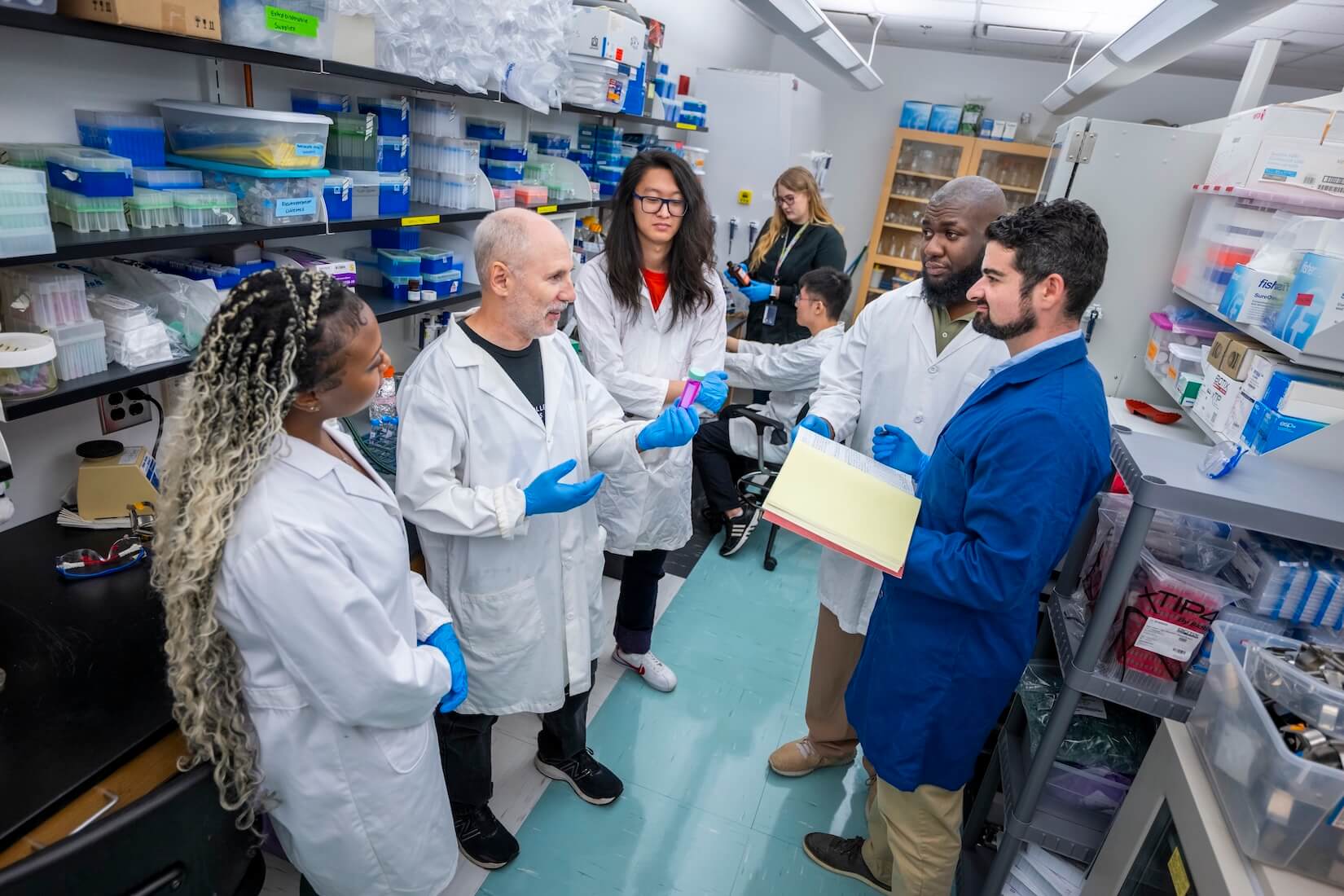 Photo including Biology Professor Eric Gilbert in the lab with team of students