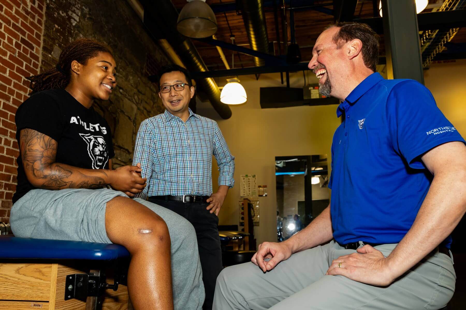 researchers sit with a student to examine an injury