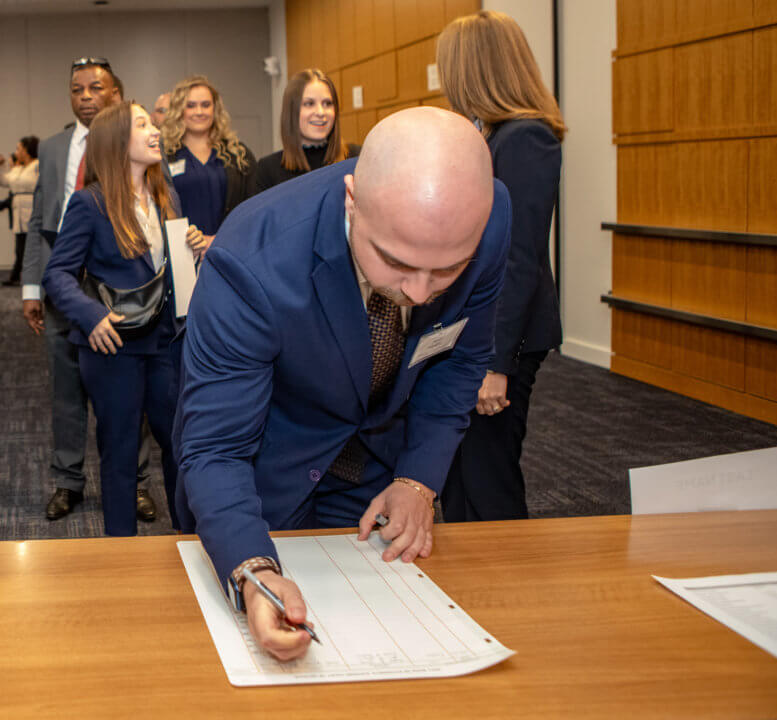 Jacob Hopkins (J.D. '25) signs his name to the official records of the court after being sworn-in as an attorney.