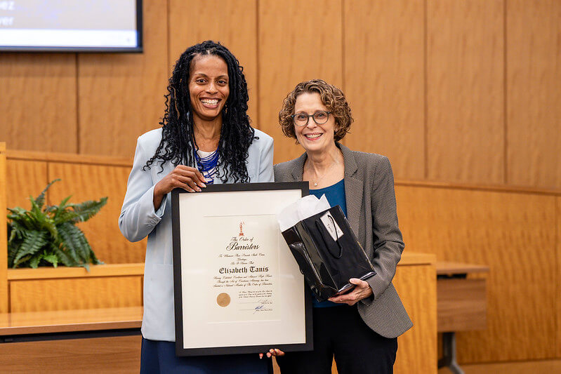 Dean Anderson presents Beth Tanis a certificate commemorating her honorary induction into the Order of Barristers.