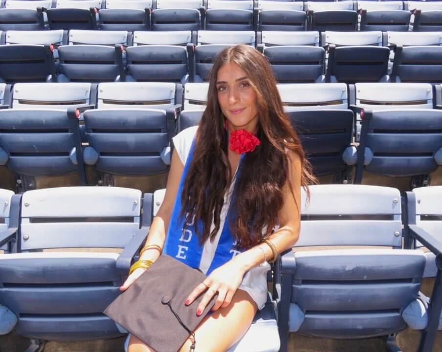 Photo of Ana Cubillo sitting in stands after graduation ceremony.