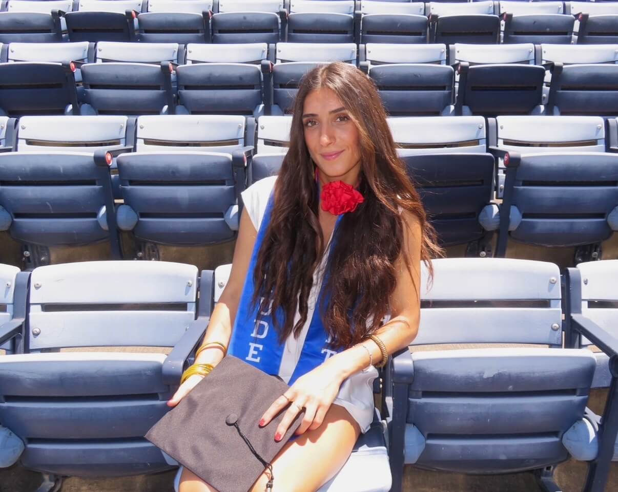 Photo of Ana Cubillo sitting in stands after graduation ceremony.