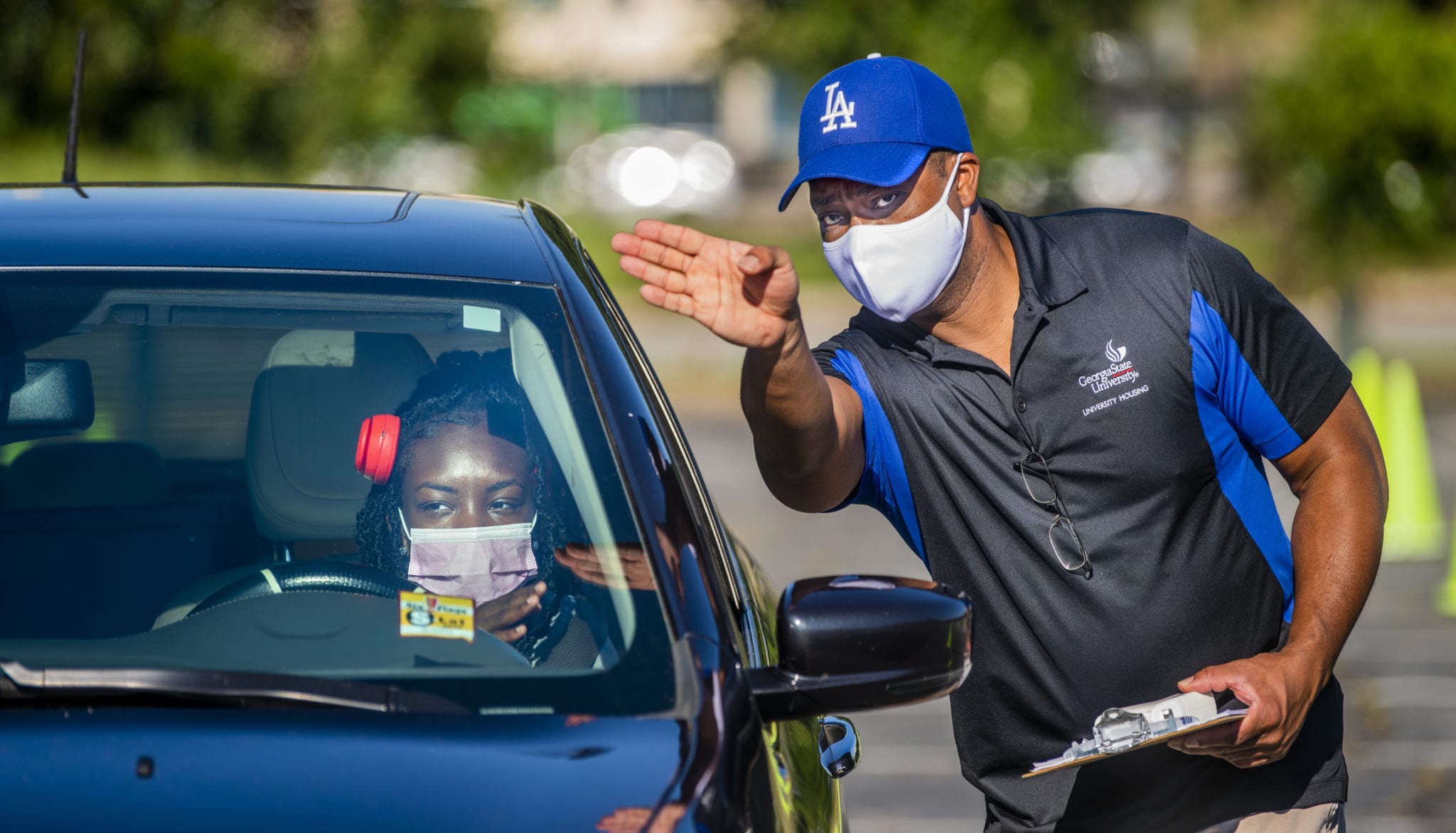Derwin Henderson from University Housing helps Jayden Dremmer navigate the Blue Lot at Center Parc Stadium (formerly Georgia State Stadium). Students checked in at the stadium and received temperature checks during scheduled move-in times.