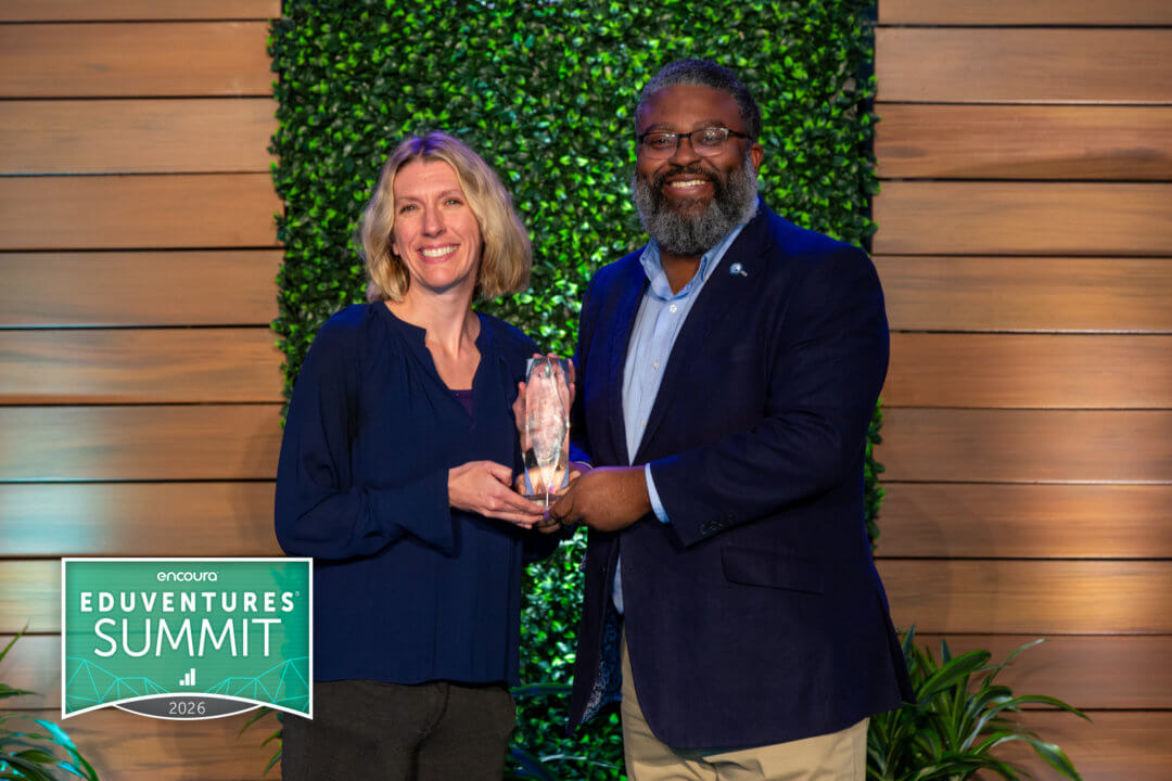 Two peope display an award.
