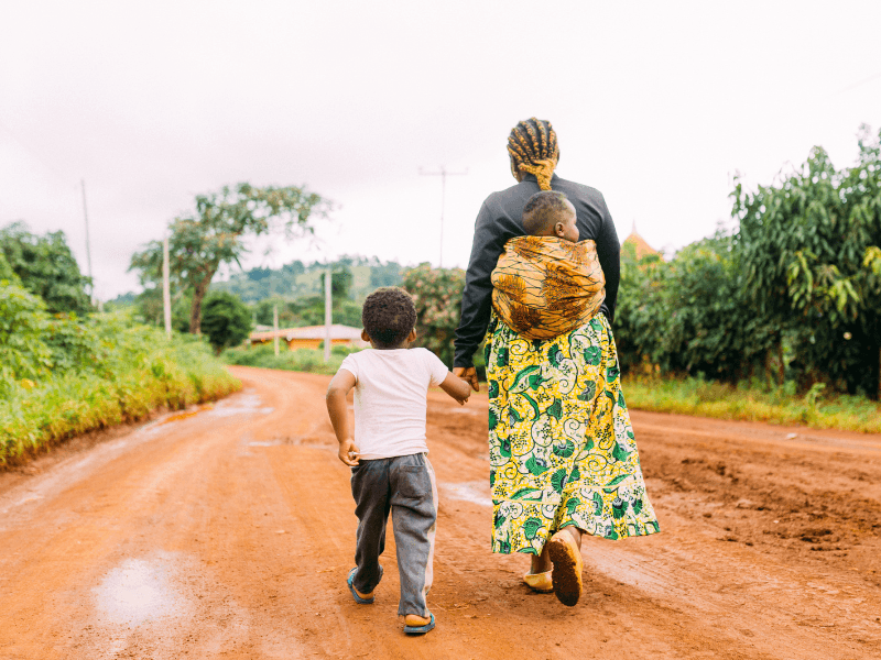 woman with two children walking in a field