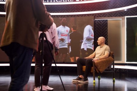A seated man is interviewed.