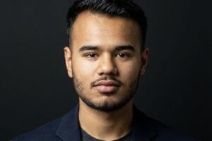 headshot image of young man in a dark jacket