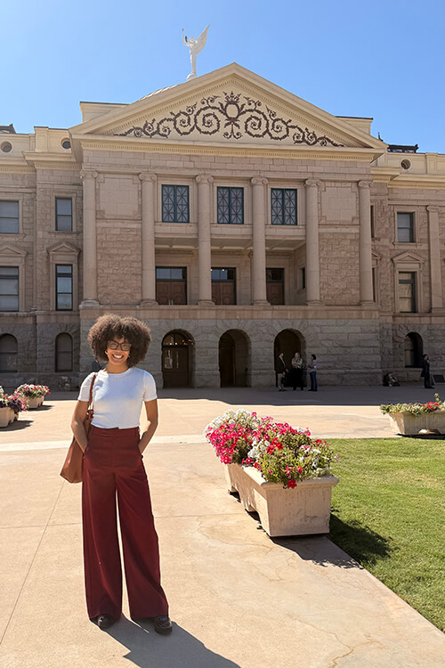 Naomi Garcia-Hector in front of the Arizona State Capitol Building while conducting meetings with legislators about housing policy.