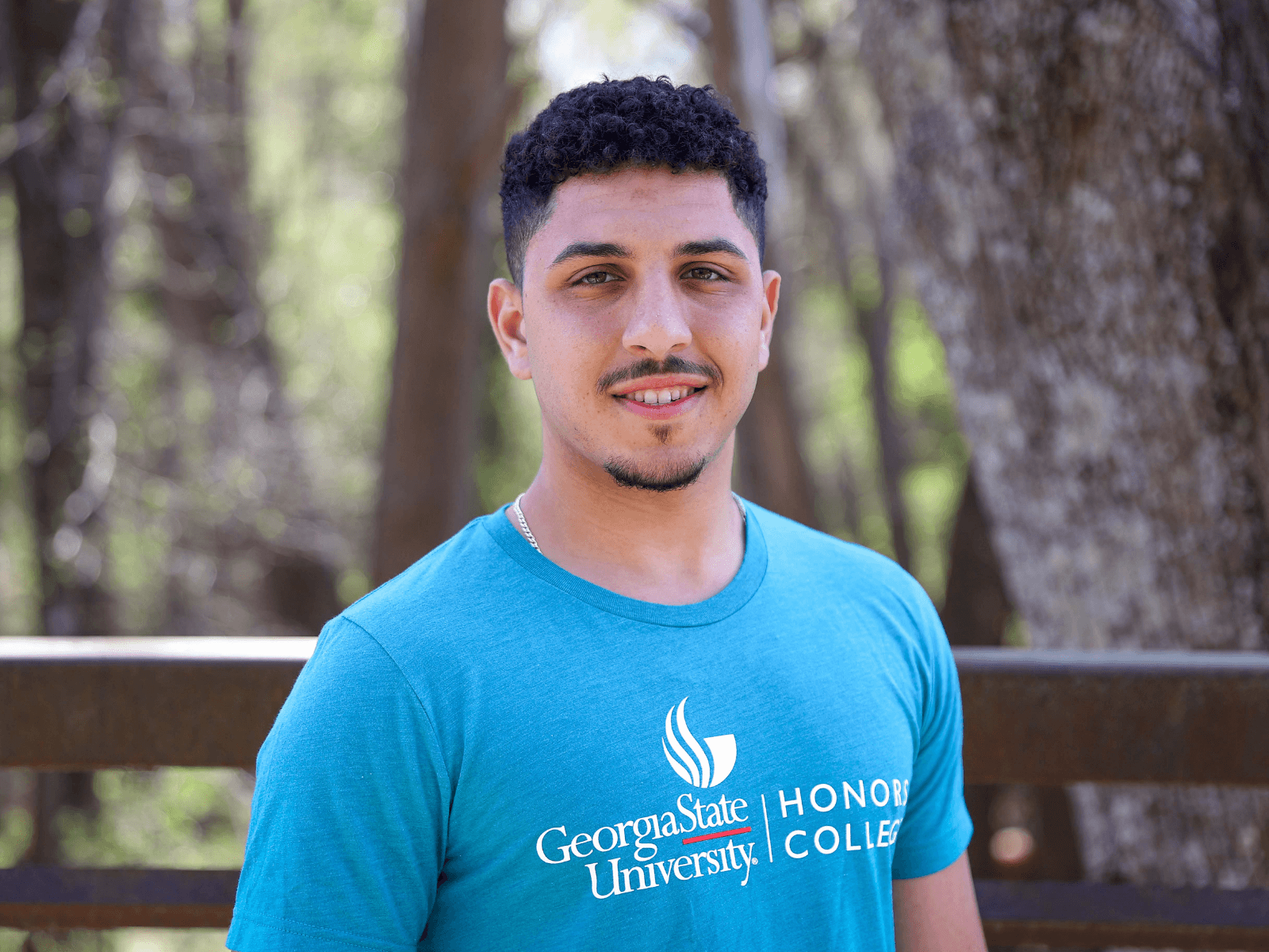 Student in Honors College Tshirt standing outside