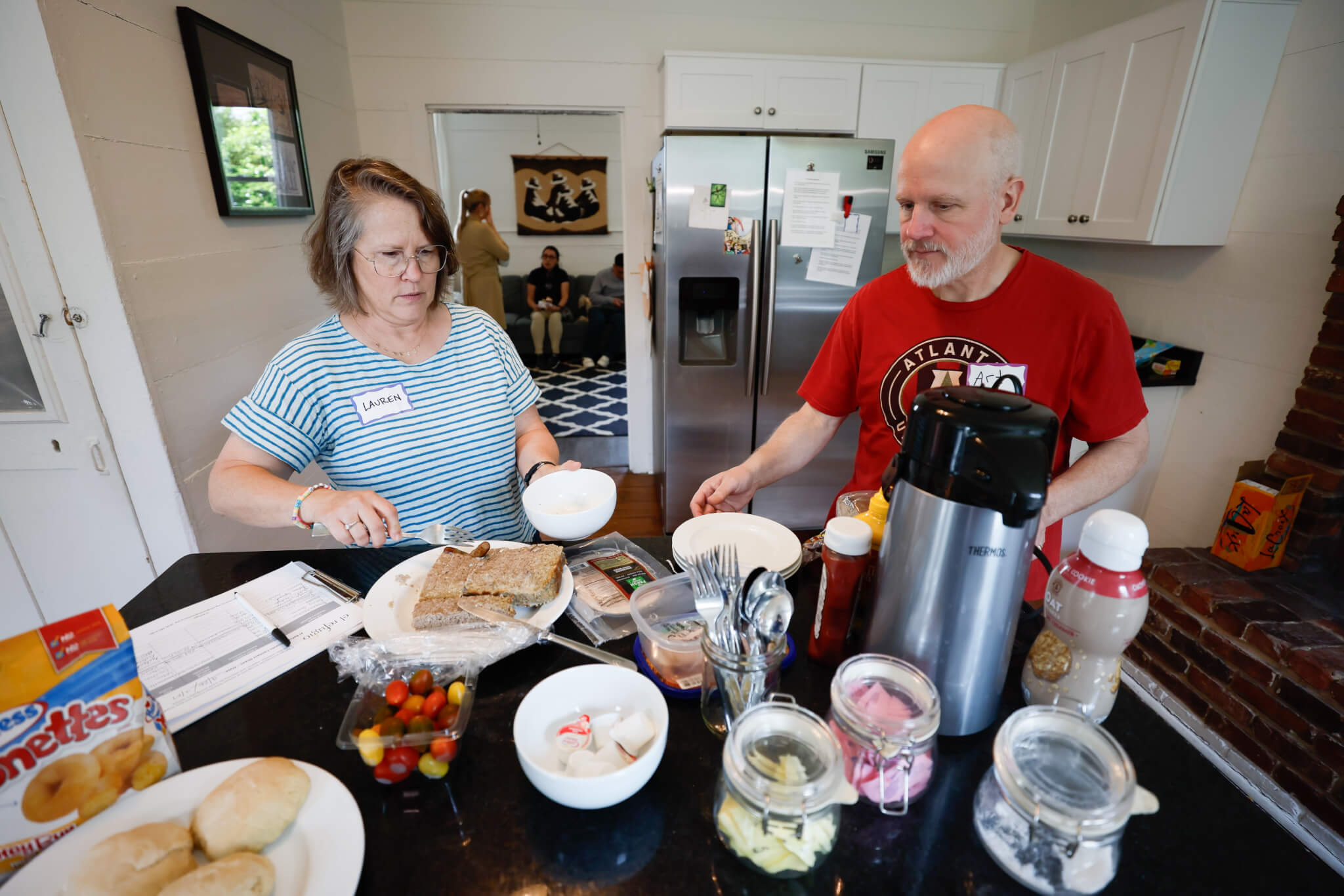 Volunteers Lauren and Arthur Waits prepare meals for the visitors at El Refugio, a place that offers accommodation for immigrant families who come to see their relatives at Stewart Detention Center. (Courtesy of Miguel Martinez/The Atlanta Journal-Constitution)