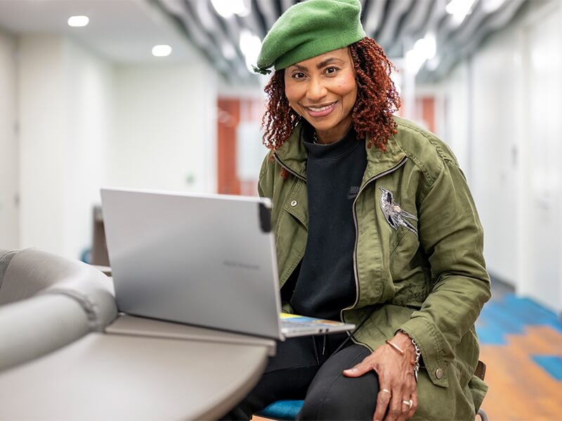 Portrait photo of Lydia Meredith seated at a laptop.