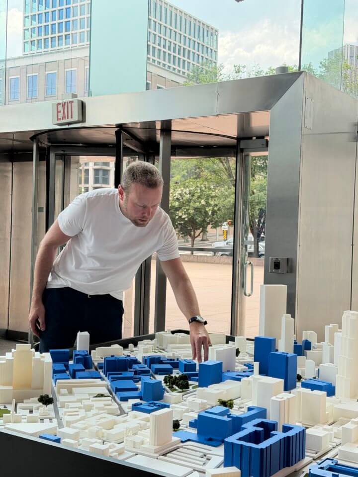 Peter Huesemann-Odom (M.F.A. ’24) places a model piece on a platform.