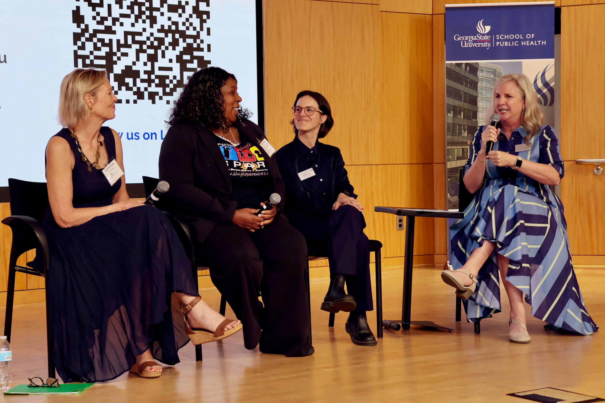 four women sitting in chairs speaking