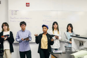 Salem Mutata speaking with four other students.