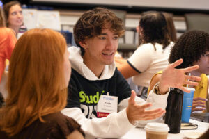 Caleb Gustavson discussing his PIRG work with others.