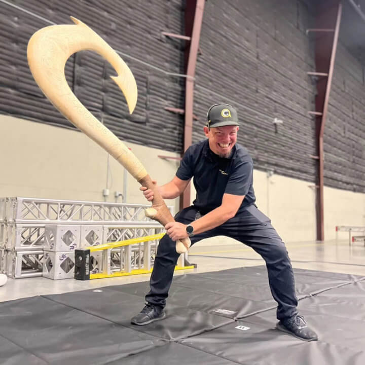 Professor of Practice James Martin holds Maui’s hook from Disney's Moana