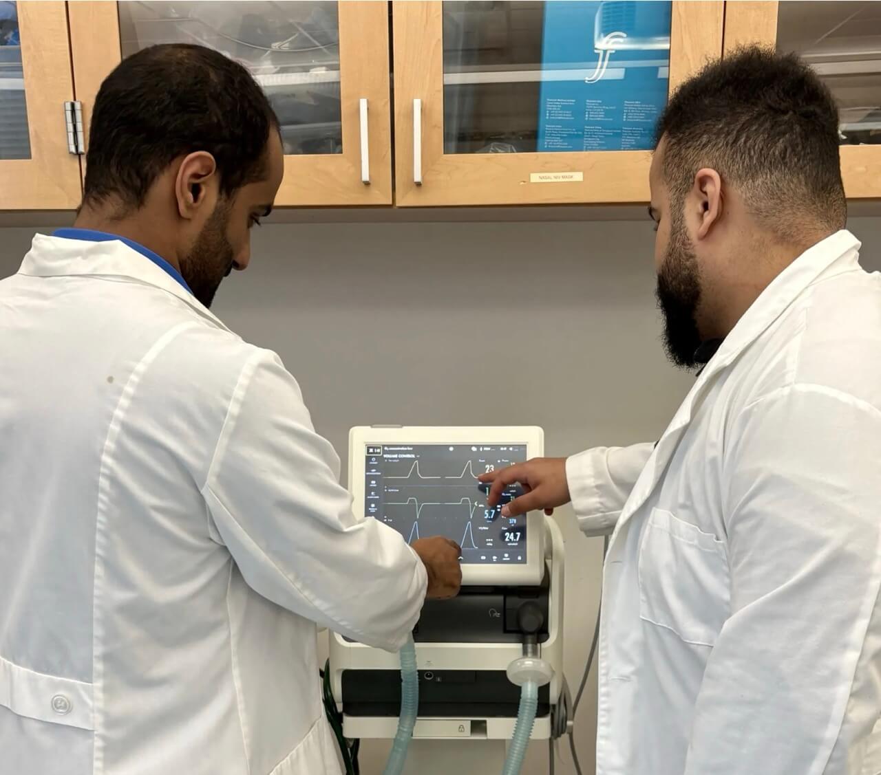 two respiratory therapists look at a monitor
