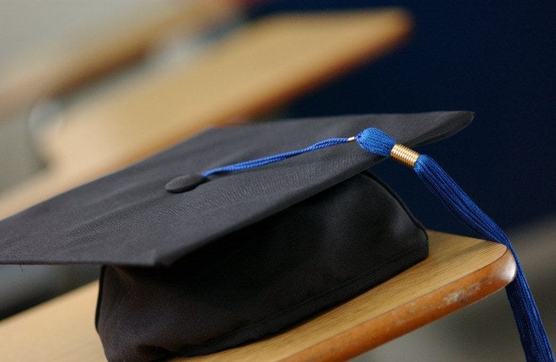 Close up of a black graduation cap with a blue tassel