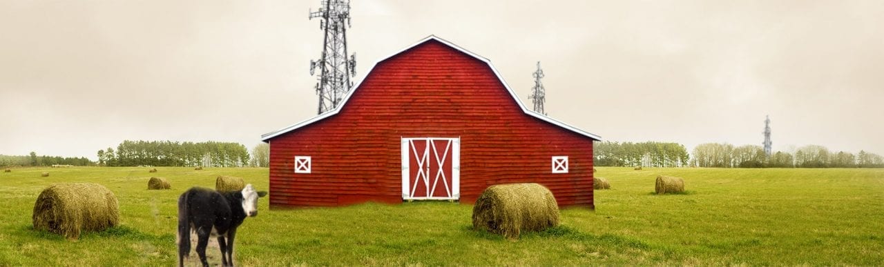 Barn in rural America with cell towers behind it.