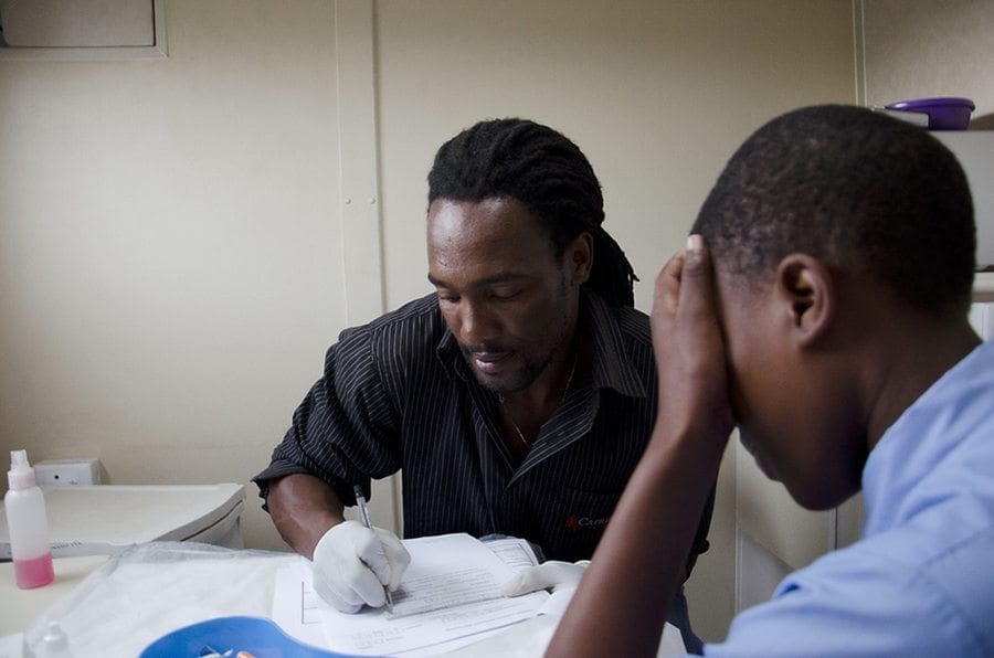 A Centre for the AIDS Programme of Research in South Africa (CAPRISA) healthcare worker obtaining answers from a schoolboy during a healthcare survey data acquisition session.
