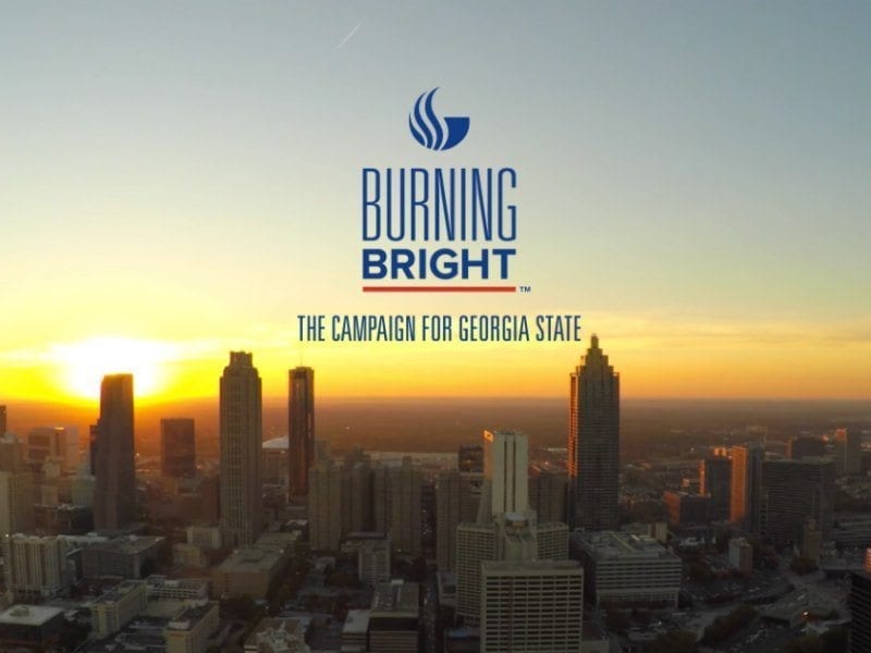 Georgia State University's Burning Bright Capital Campaign logo over a cityscape background