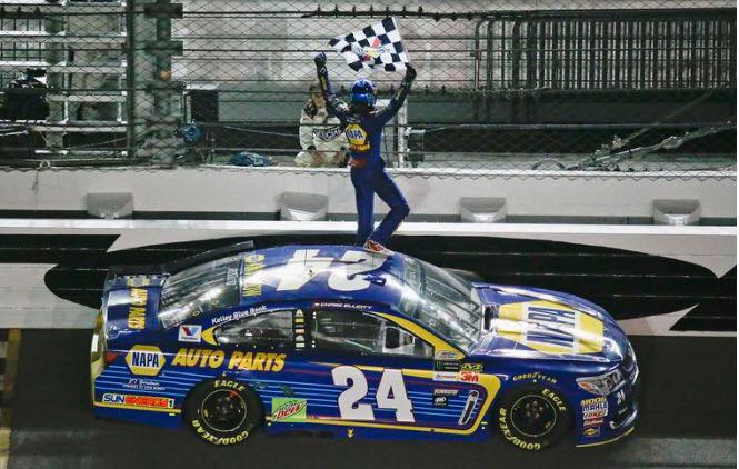 Chase Elliott waving a flag on top of his race car