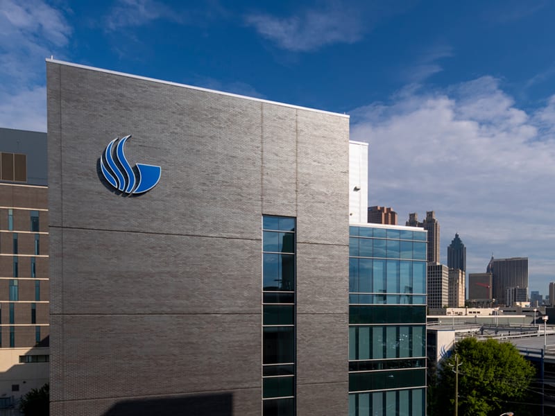 Georgia State University’s blue flame logo is seen on the Research Science Center against the backdrop of the downtown Atlanta skyline.