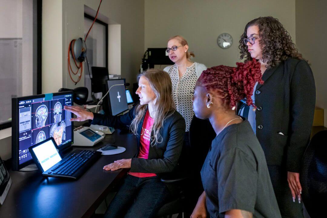 group of researchers and students review brain scans