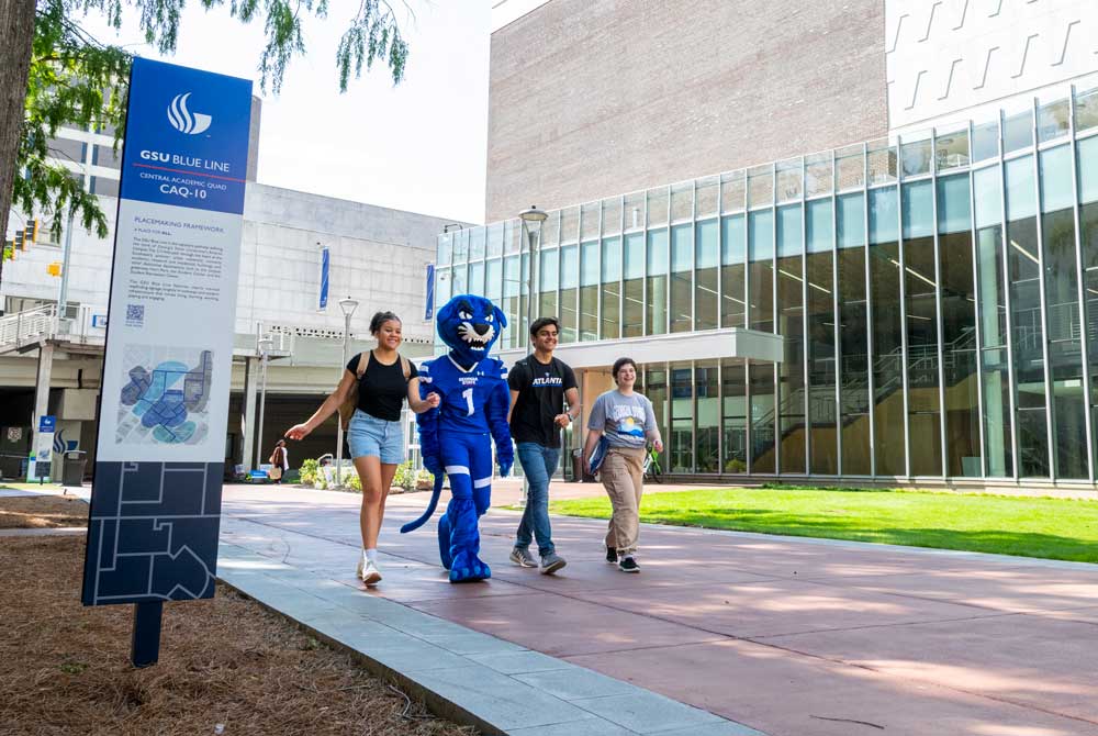 students and panther mascot walking through campus