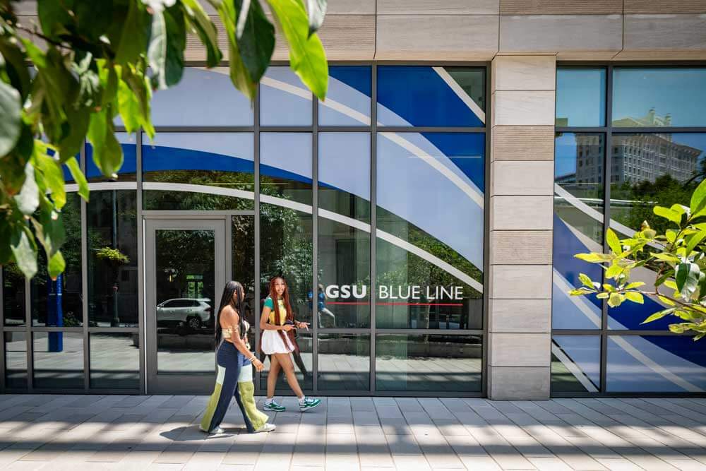 students walking past campus building
