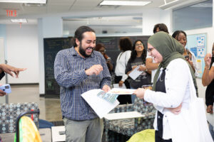 An Honors advisor and student laughing togeter at one of the stations during Community Pop-In