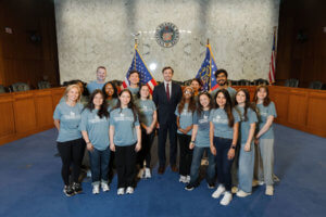 group of students standing with a U.S. Senator i