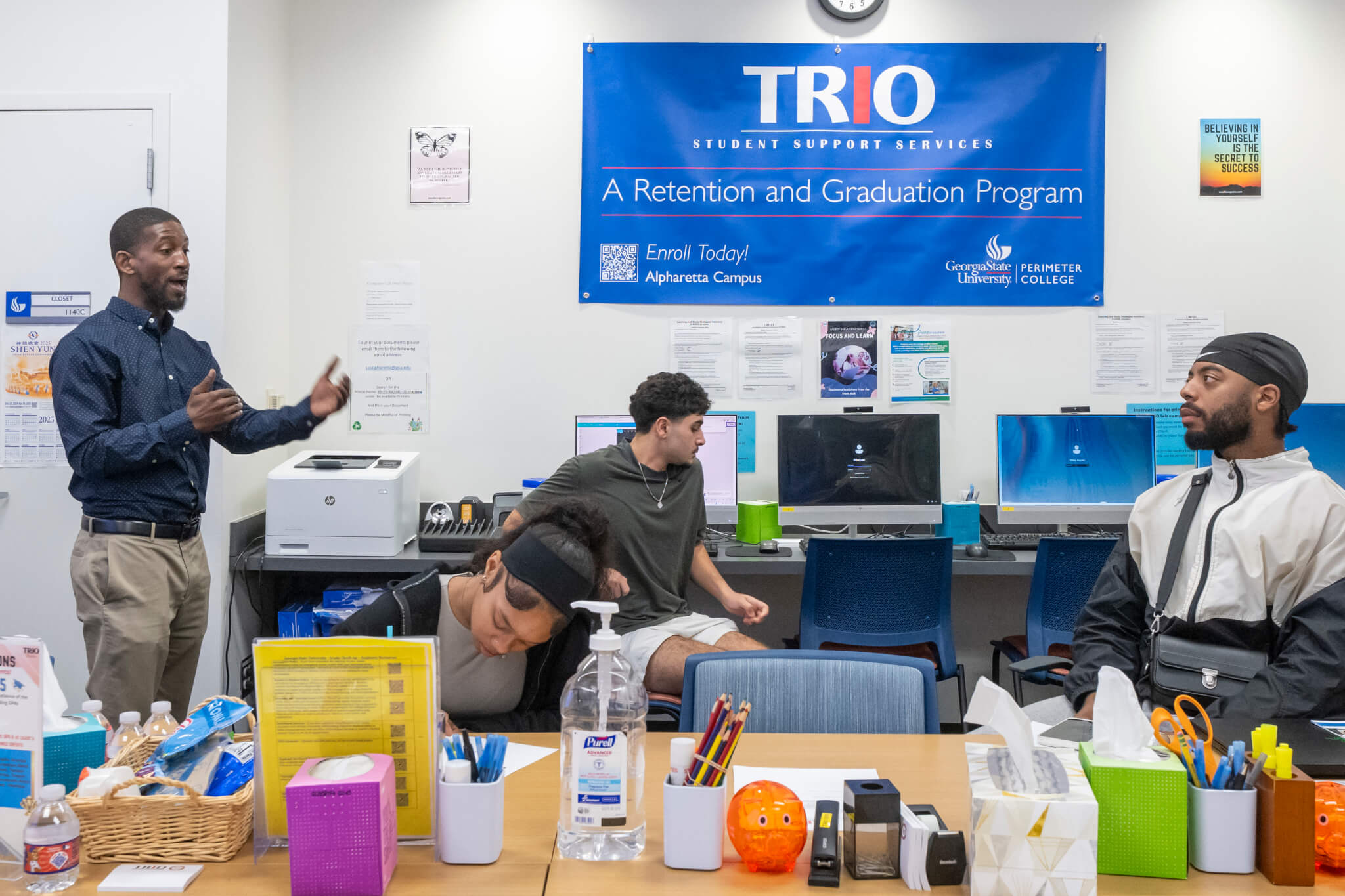 man talking to students in classroom-type setting