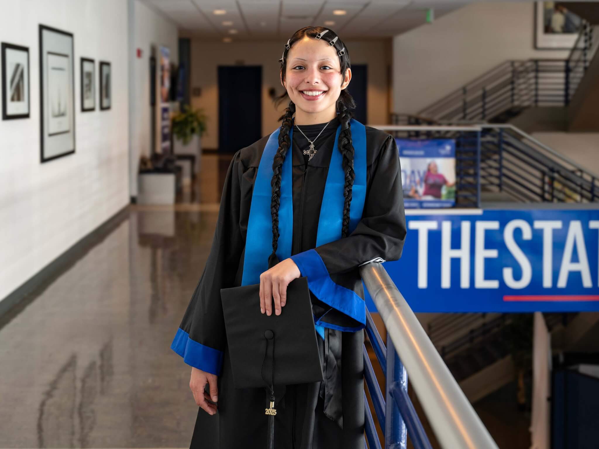 Heart Carbajal poses in graduation regalia inside Georgia State University, a graduate of the Department of Africana Studies.