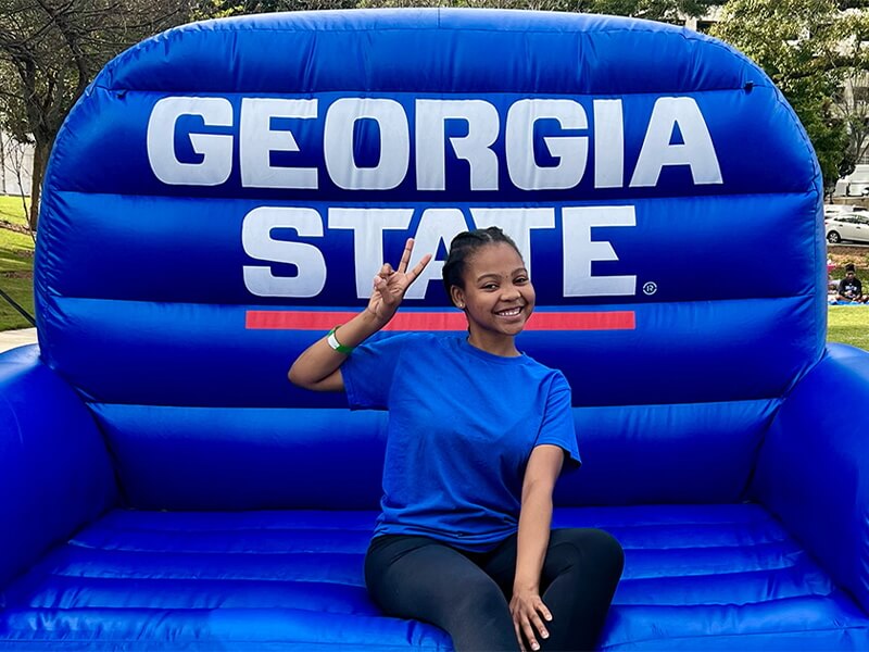 Salem Mutata poses on a giant inflatable Georgia State chair.