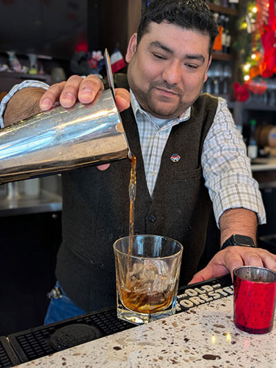 Ramirez pours a cocktail at Bastille Brasserie & Bar.