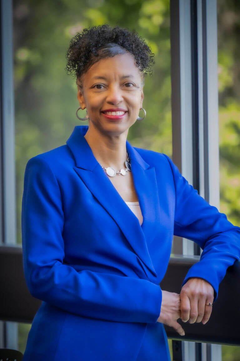 woman in blue suit smiling at camera