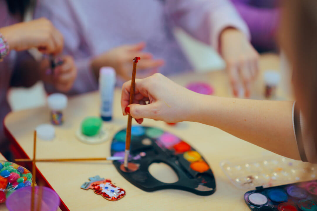 hands of adults and children painting