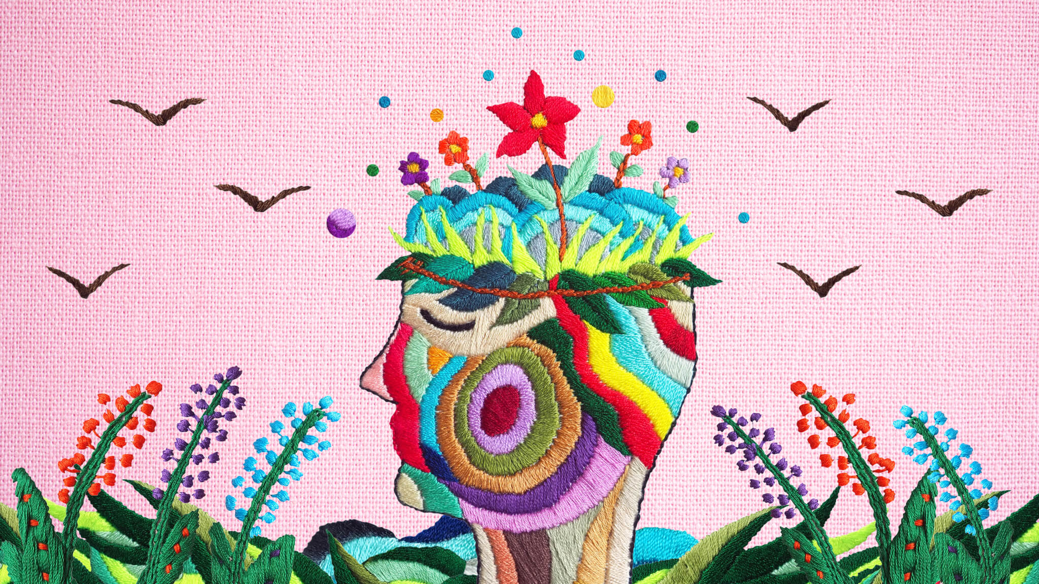 an embroidered image showing a multicolor face and head with flowers