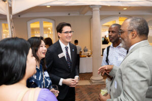 Dean Thomas Vicino talking to alumni in casual group