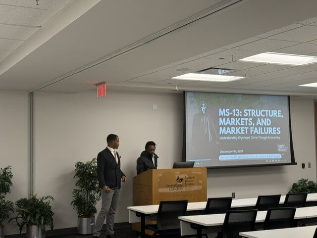 Students give a presentation from a podium.