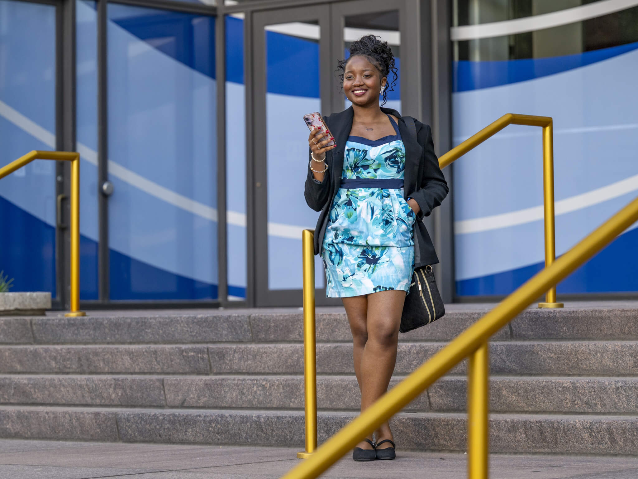 SGA President Zaina Jean-Bart walking down the stairs outside of a GSU downtown campus building