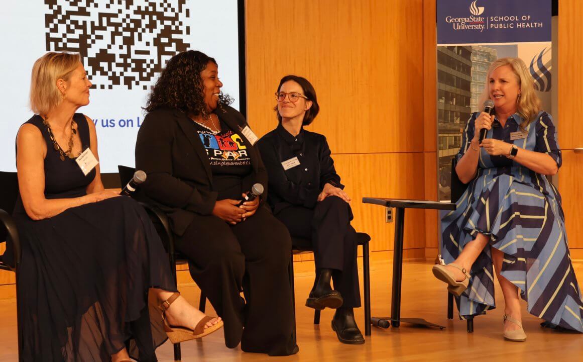 three women sitting on a stage