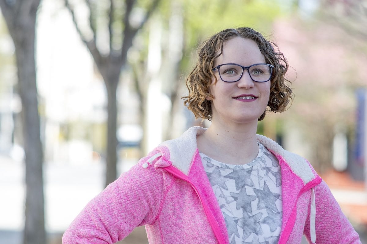 White female in pink hoody with classes
